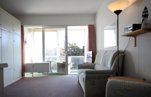een woonkamer met een bank en een groot raam bij Haus Seehuette Wohnung 402 in Cuxhaven