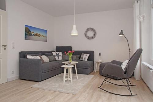 a living room with a couch and a table and chairs at Strandlaeufer in Cuxhaven