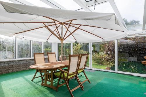una mesa y sillas bajo una sombrilla en un patio en Haus Cux, App 7 en Duhnen