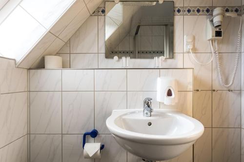een badkamer met een wastafel en een spiegel bij Kiefernglück App 5 in Norderney