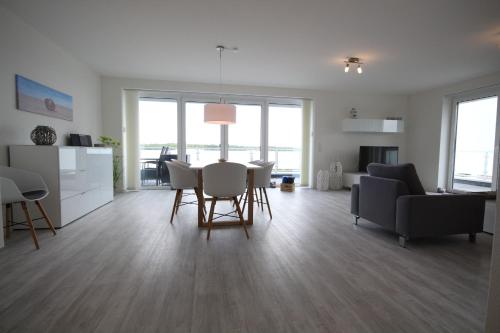 a kitchen and living room with a table and chairs at Quartier Hohe Geest _ Wohnung Meer in Cuxhaven