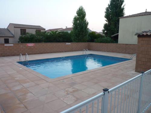 a swimming pool with a fence around it at Un petit coin de paradis en bord de mer in Vias