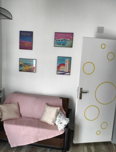 a living room with a pink couch and a door at La Casita: Studio cosy indépendant de 25 m² in Les Sables-dʼOlonne