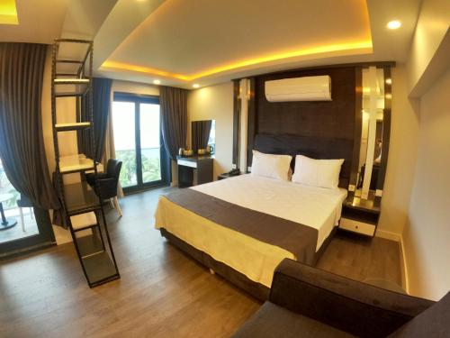 a bedroom with a large bed and a room with a desk at avsa extra vagant hotel in Avşa Adası