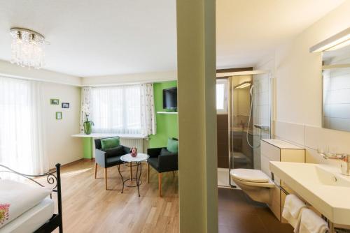 a bathroom with a sink and a toilet and a table at Hotel Sternen in Buochs