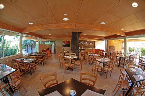 シルミオーネにあるHotel Smeraldoの木製のテーブルと椅子が備わる空きレストランです。