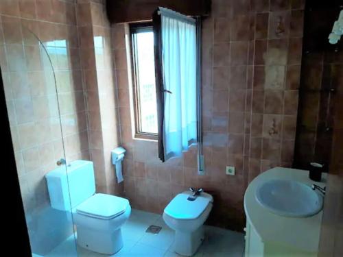 uma casa de banho com um WC e um lavatório em Sella em Arriondas