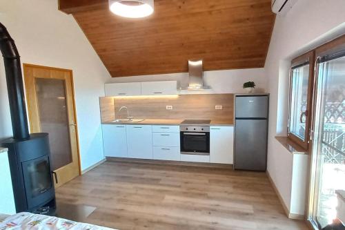 a kitchen with white cabinets and a sink and a stove at Cottage near river Kolpa, vineyards,top location. in Adlešiči