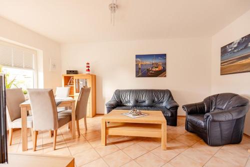 ein Wohnzimmer mit einem Sofa und einem Tisch in der Unterkunft Weg App 2 in Norderney