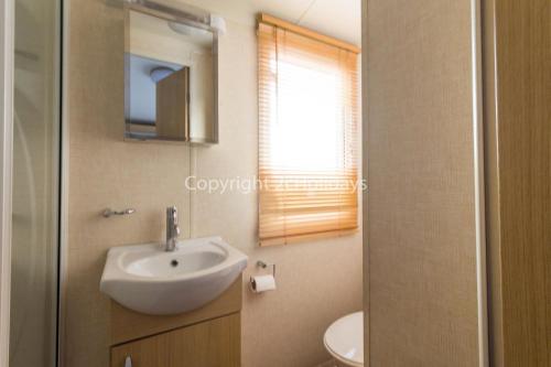 La salle de bains est pourvue d'un lavabo et d'un miroir. dans l'établissement 8 Berth, Dog Friendly Caravan At Haven Caister In Norfolk Ref 30031b, à Great Yarmouth