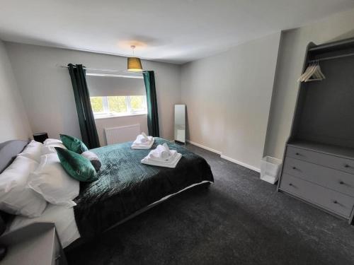 a bedroom with a bed with towels on it at Jersey Cottage in Horseheath