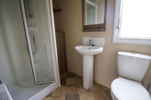 a bathroom with a toilet and a sink and a shower at Superb 8 Berth Caravan At Caister Beach In Norfolk Ref 30073f in Great Yarmouth