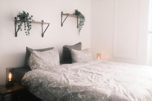 een slaapkamer met een wit bed met 2 kussens bij Le Rotche I in La-Roche-en-Ardenne