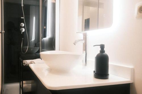 een badkamer met een zwarte zeepdispenser op een wastafel bij Le Rotche I in La-Roche-en-Ardenne