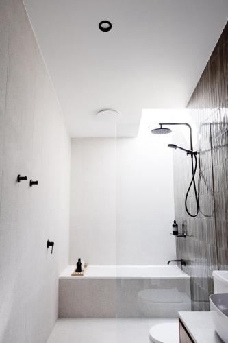 a white bathroom with a tub and a sink at Luxury Alpine Stay with Epic Views at Mt Buller foothills in Merrijig
