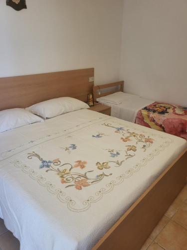 um quarto com duas camas com um cobertor na cama em La casetta em San Vito Chietino