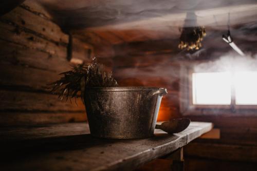 a metal bucket sitting on a table with a plant at Vienkiemio Oazė - Namelis Prie Upelio in Galvokai