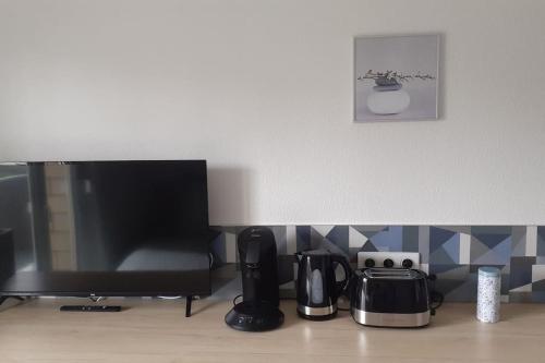 - un comptoir de cuisine avec une cafetière et une télévision dans l'établissement Résidence calme, parking gratuit, à Illzach