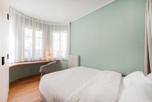 a bedroom with a white bed and a window at #White Lotus by halu! Apartments in Thessaloniki