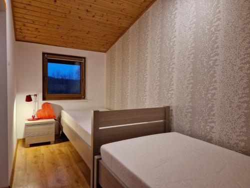 1 dormitorio con 2 camas y ventana en Domek Mazurski Chill, en Jakubowo