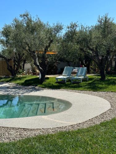 a pool with two lounge chairs and a table at THIRES Guesthouse in Vasilikos