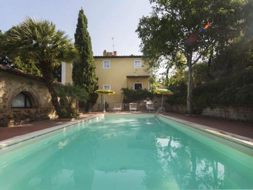 a large blue swimming pool in front of a house at Residence La Casina in Castagneto Carducci