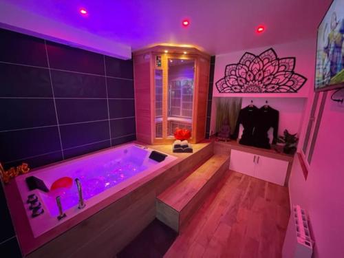 a large bathroom with a tub with purple lighting at Spamoureux EPINAY in Épinay-sous-Sénart