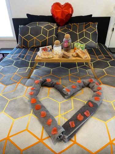 een kamer met een bed met een tafel en een hart bij Spamoureux EPINAY in Épinay-sous-Sénart