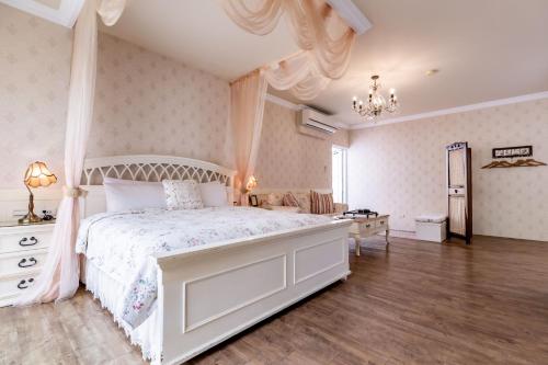 a bedroom with a large white bed and a dresser at Flower Happiness Homestay in Jian