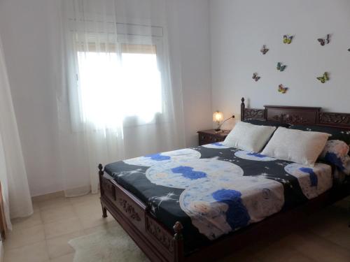 um quarto com uma cama com um edredão florido em Beach House Roda de Bera em Roda de Bará