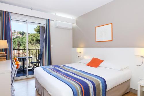 a bedroom with a bed and a balcony at Hotel Méditerranée in Collioure