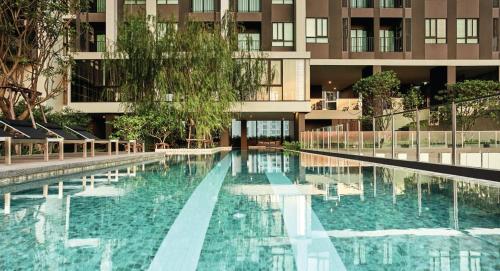 a large swimming pool in front of a building at Srinakarin Lasalle 2 BR Bangkok in Bangna