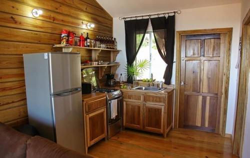 a kitchen with a refrigerator and a stove and a door at apartmán Roatan A24 Czech Village in Arrozal