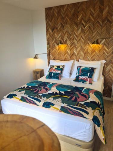 - une chambre dotée d'un grand lit avec des couvertures et des oreillers colorés dans l'établissement Casetta Bianca, à Porto-Vecchio