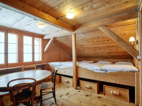 a room with two bunk beds and a table at Gästehaus Hof Maiezyt in Habkern