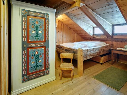 a bedroom with a bed and a chair in a room at Gästehaus Hof Maiezyt in Habkern