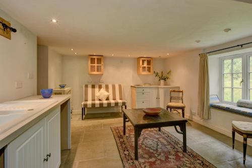 Bradford Mill في تيفرتون: مطبخ وغرفة معيشة مع طاولة وأريكة