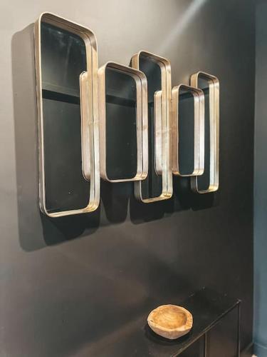 un mur avec trois fenêtres et un bol sur une table dans l'établissement Jolie villa à quelques pas du centre-ville., à Nîmes