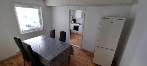 cocina con mesa, nevera y ventana en Sleep In, en Nordmannset