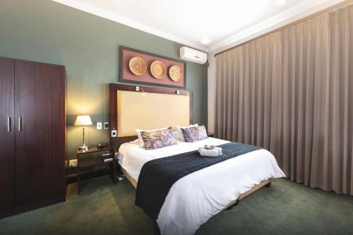 a hotel room with a large bed in it at The Graham Hotel in Grahamstown