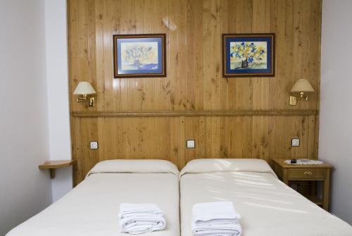 a bedroom with a bed with two towels on it at Hotel Restaurante Prado in Boal