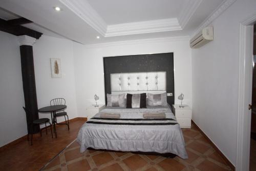 a bedroom with a large bed and a table at Alojamiento el Chaparro Barbate junto a la venta el loro in Barbate