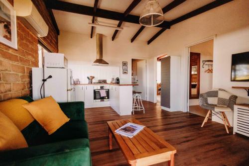 a living room with a green couch and a table at Margaret River Holiday Cottages in Margaret River Town