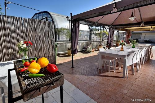 a patio with a table with fruits and vegetables on it at אחוזת אלכסנדר in Elifelet