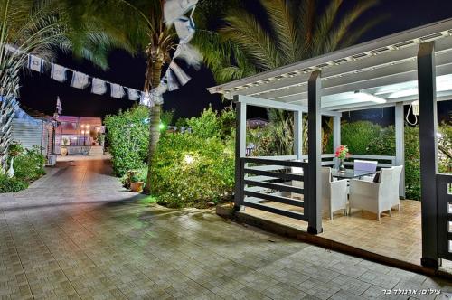 a patio of a house with a table and a table at אחוזת אלכסנדר in Elifelet