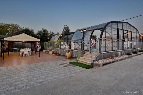 a building with a tent and a table and chairs at אחוזת אלכסנדר in Elifelet
