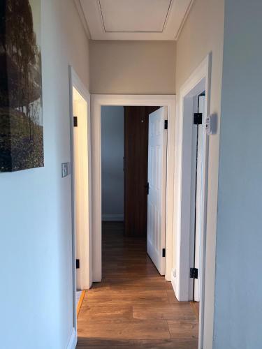 an empty hallway with two doors and a wooden floor at Enniscrone - AitEabha Country Cottage in Enniscrone