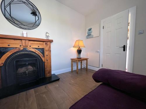 a living room with a fireplace and a mirror at Enniscrone - AitEabha Country Cottage in Enniscrone