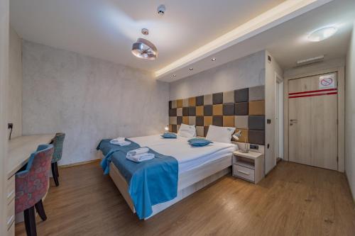 a bedroom with a bed and a table and chairs at Hotel City Code Vizura garni RENEW in Belgrade