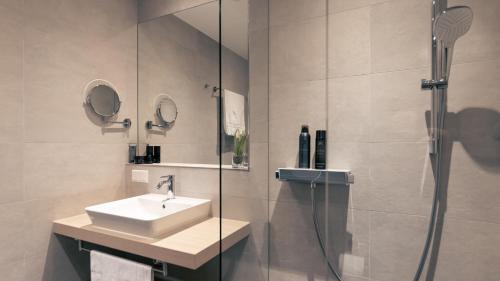 a bathroom with a sink and a shower at Nena Apartments SPREEblau in Berlin